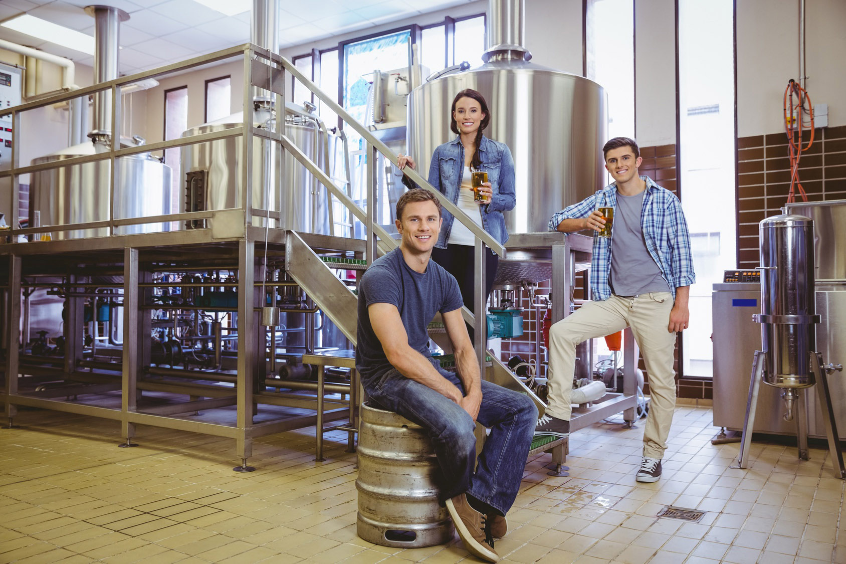 Three people posed for photo in beverage plant of Columbia distributing