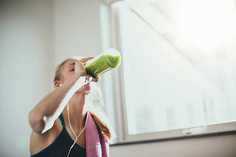 woman drinking after exercising