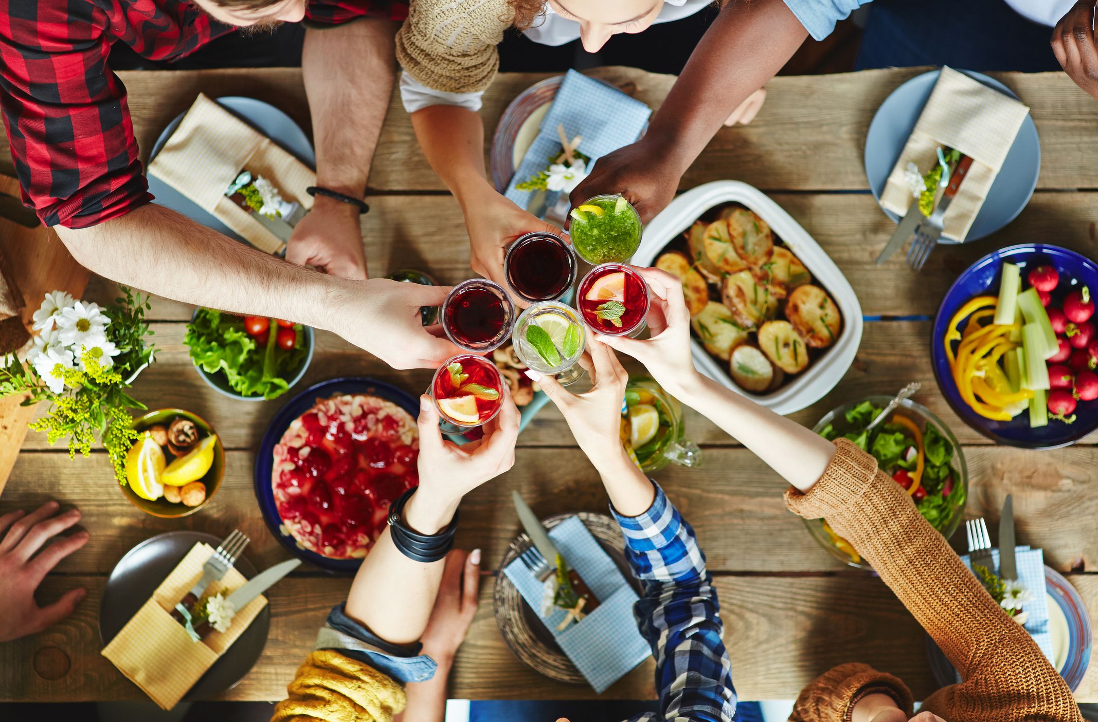 Friends toasting glasses over picnic table for get-together