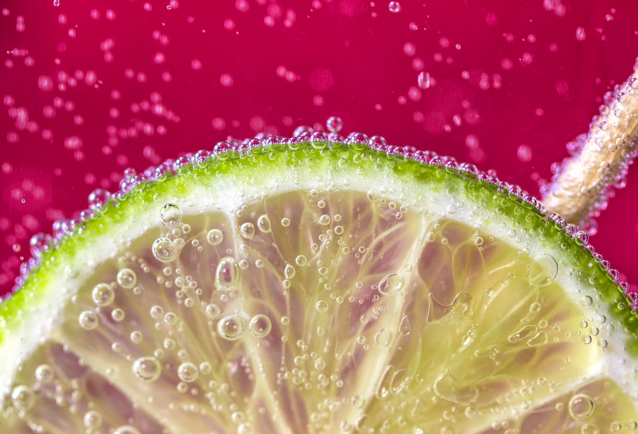 Slice of lime floating in fizzy drink