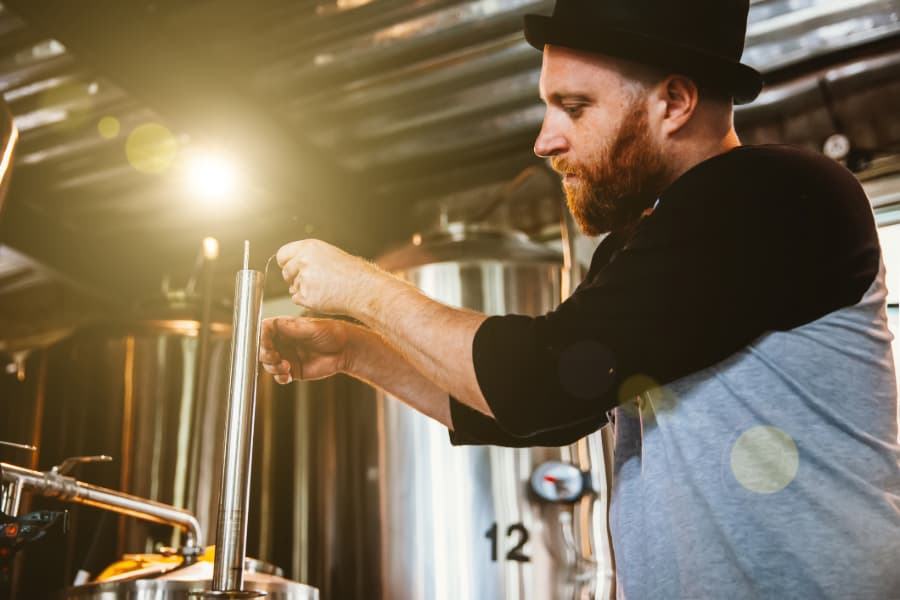 Man Operating Machinery In Craft Brewery