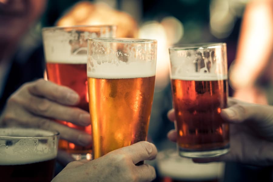 Group of people toasting with pints of beer 