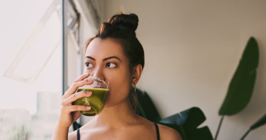 Woman drinking green juice