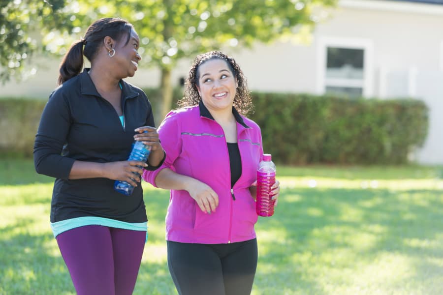 Two Women Walking With Energy Drinks