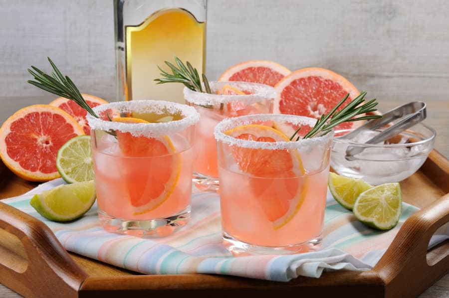Pink cocktails with salted rims and grapefruit and lime slices