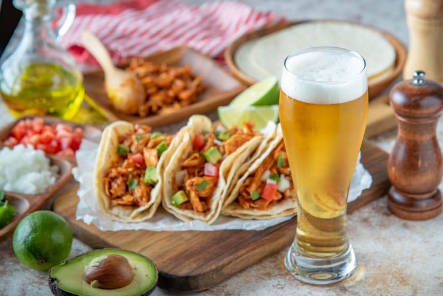 Shredded chicken tacos and glass of beer