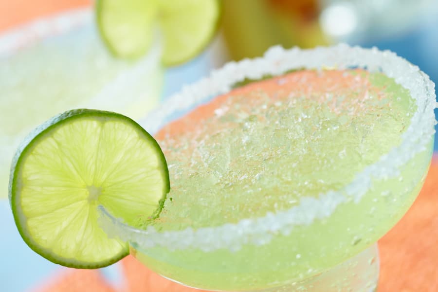 Closeup of margarita with salt on rim and lime garnish