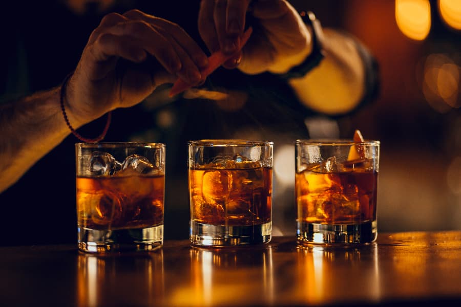 A bartender makes whiskey and bourbon cocktails