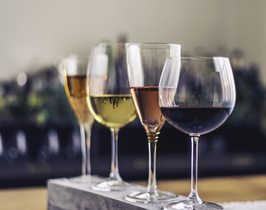 Four different wine glasses with different types of wine
