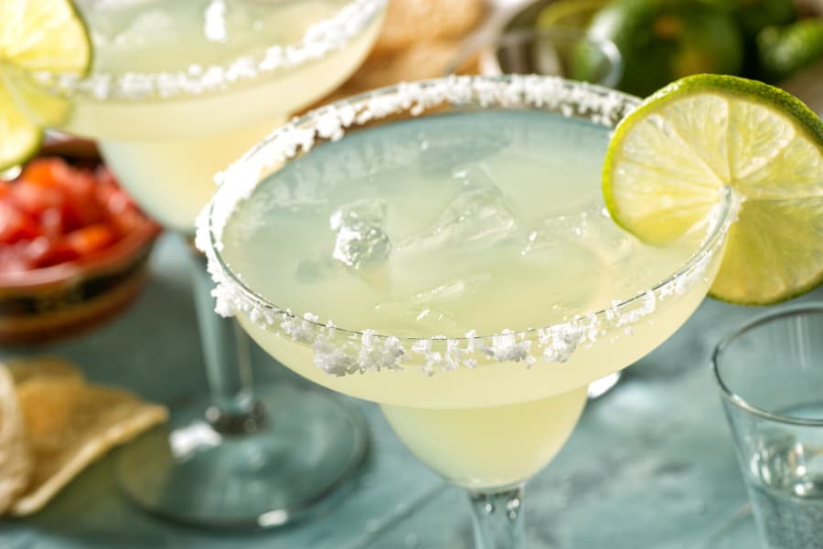 Margaritas with salted rims and lime slices 