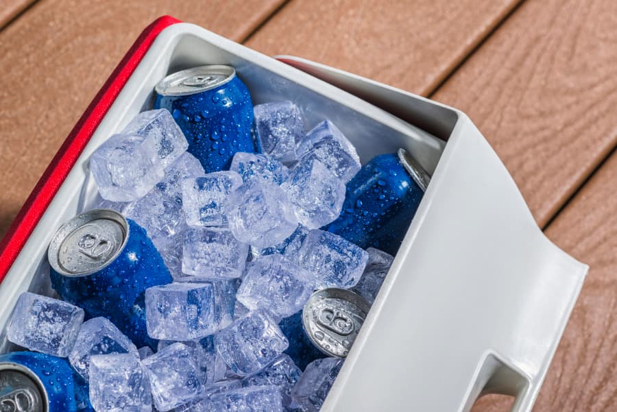 Blue beer cans in red cooler on ice
