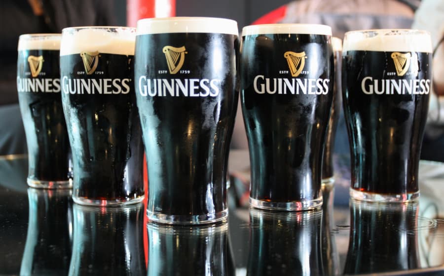 Five glasses of Guinness beer sitting on bar countertop