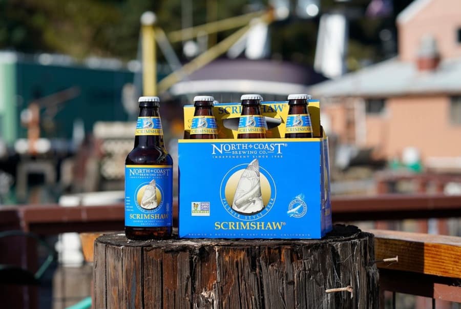 North Coast Brewing Scrimshaw 6 pack sitting on tree stump