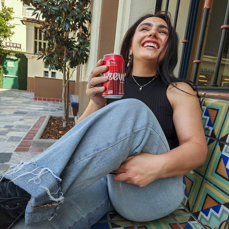 Person holding Zevia soda can and smiling