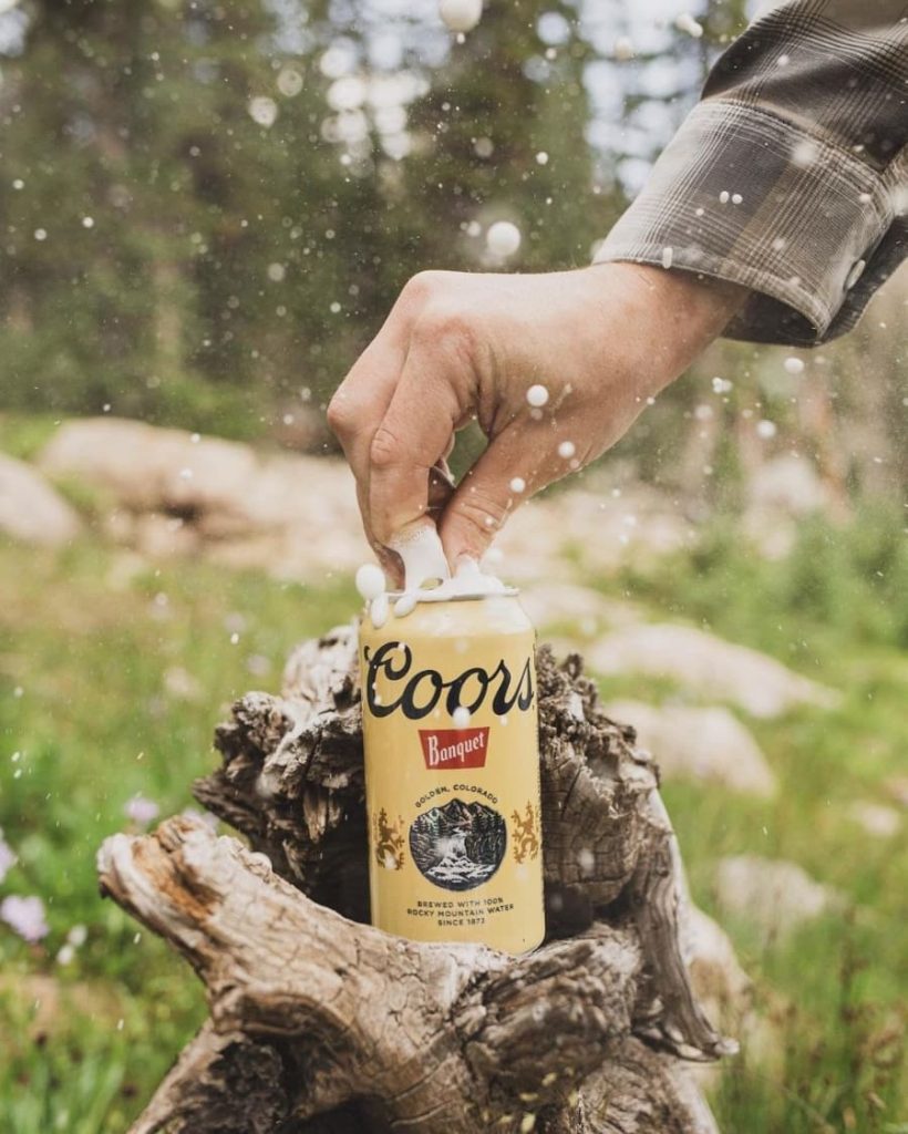 Coors can being opened on a tree stump