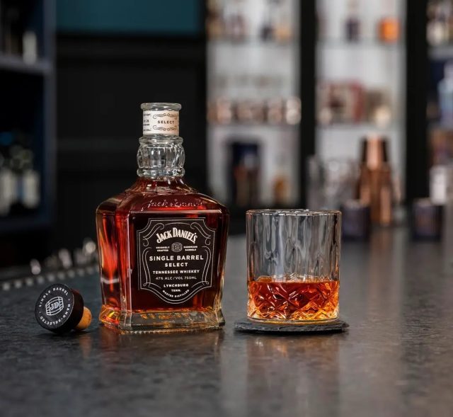 Jack Daniel’s whiskey bottle next to glass