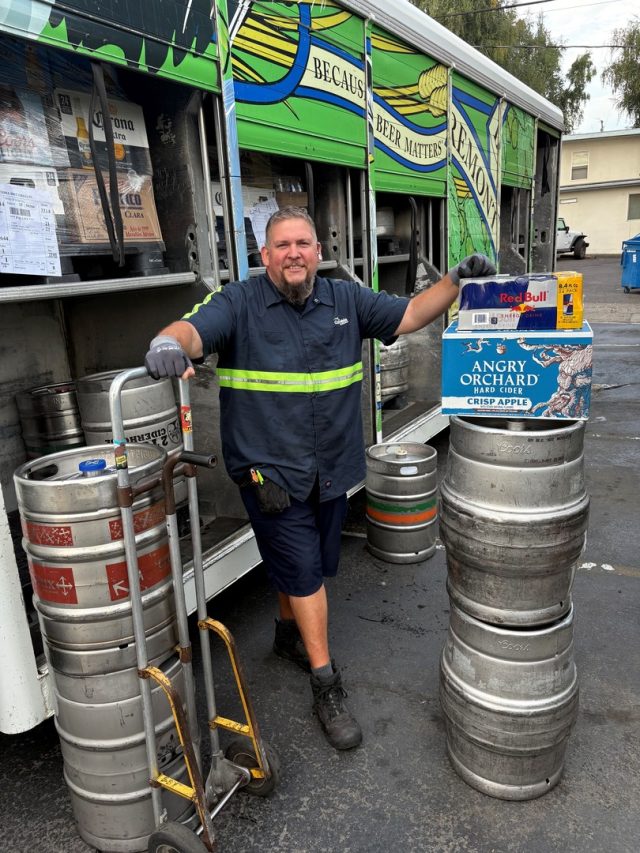 James Canales at warehouse next to kegs