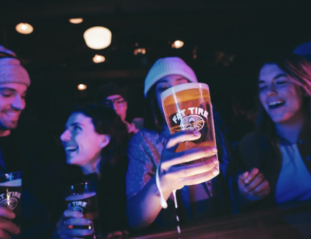 Young adults holding fat tire beer